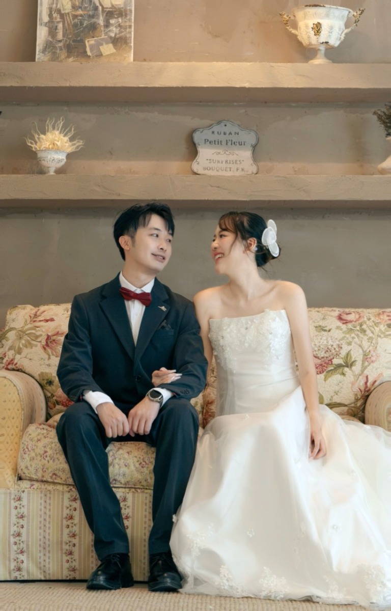 The couple seated together in a vintage room
